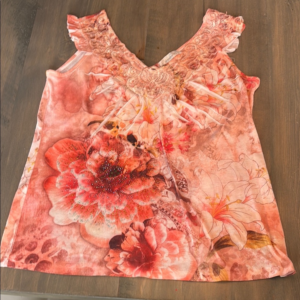 Super cute Orange Sleeveless Ruffled Smocked top with flower appliqué.